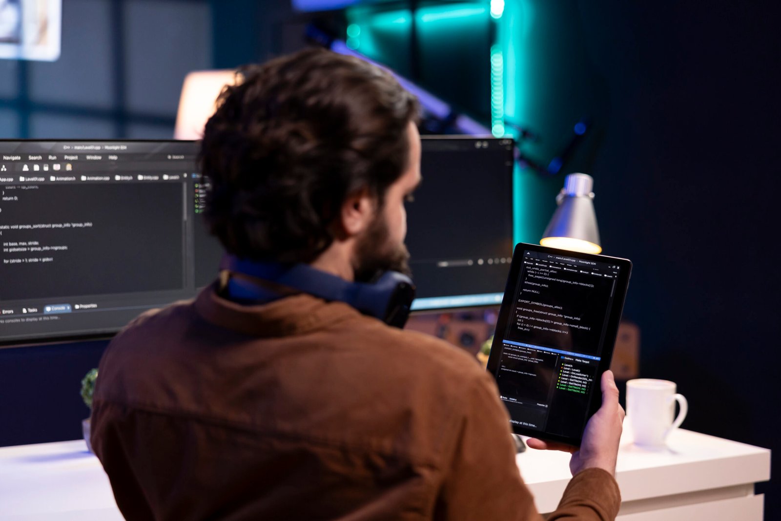 Man doing software quality assurance using tablet, reading source code