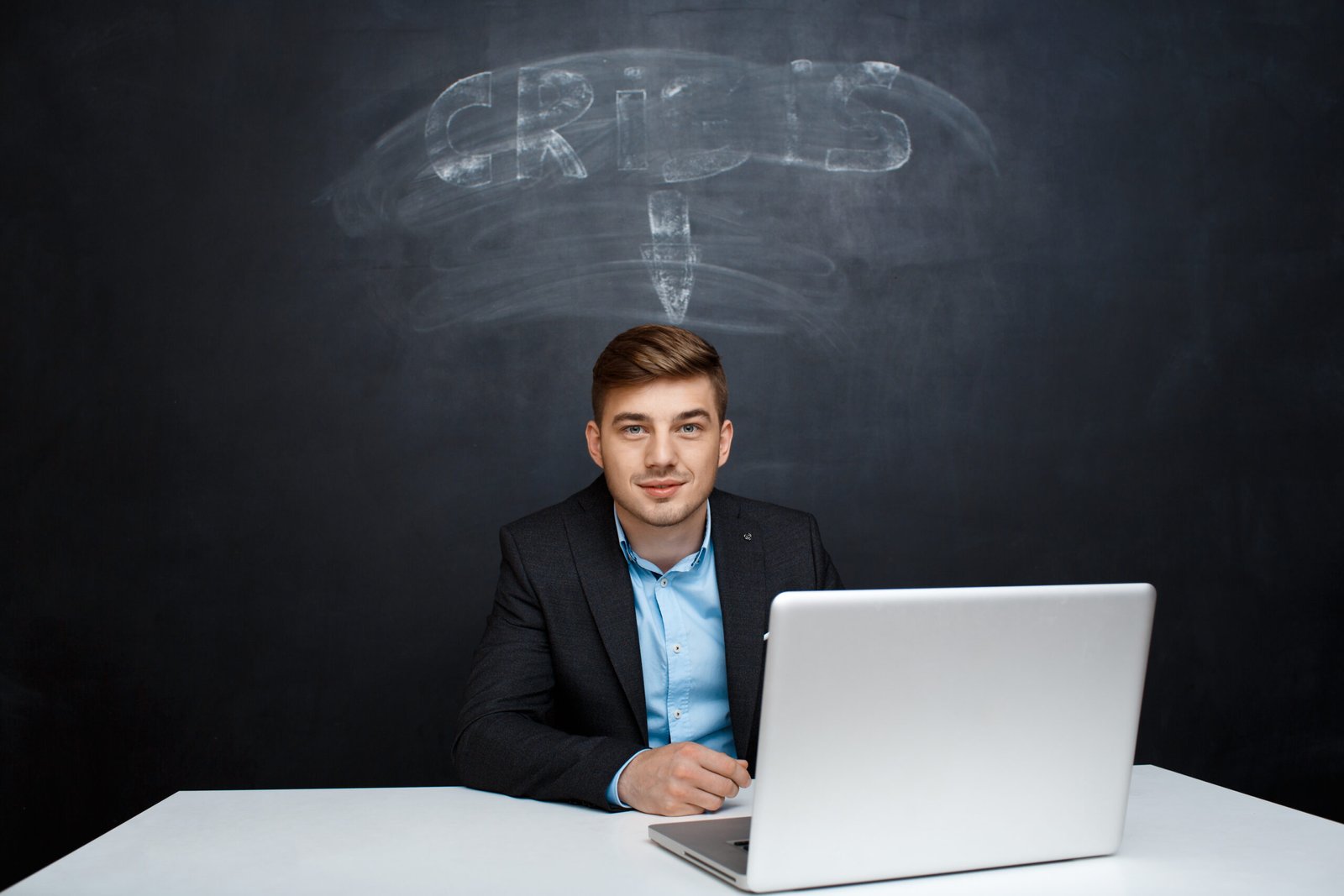 Picture of smiling man over blackboard with crisis inscription